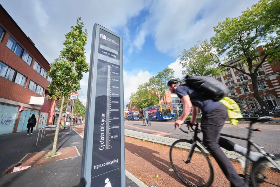 Black bike counter with cyclists passing by on Manchester, UK bike path
